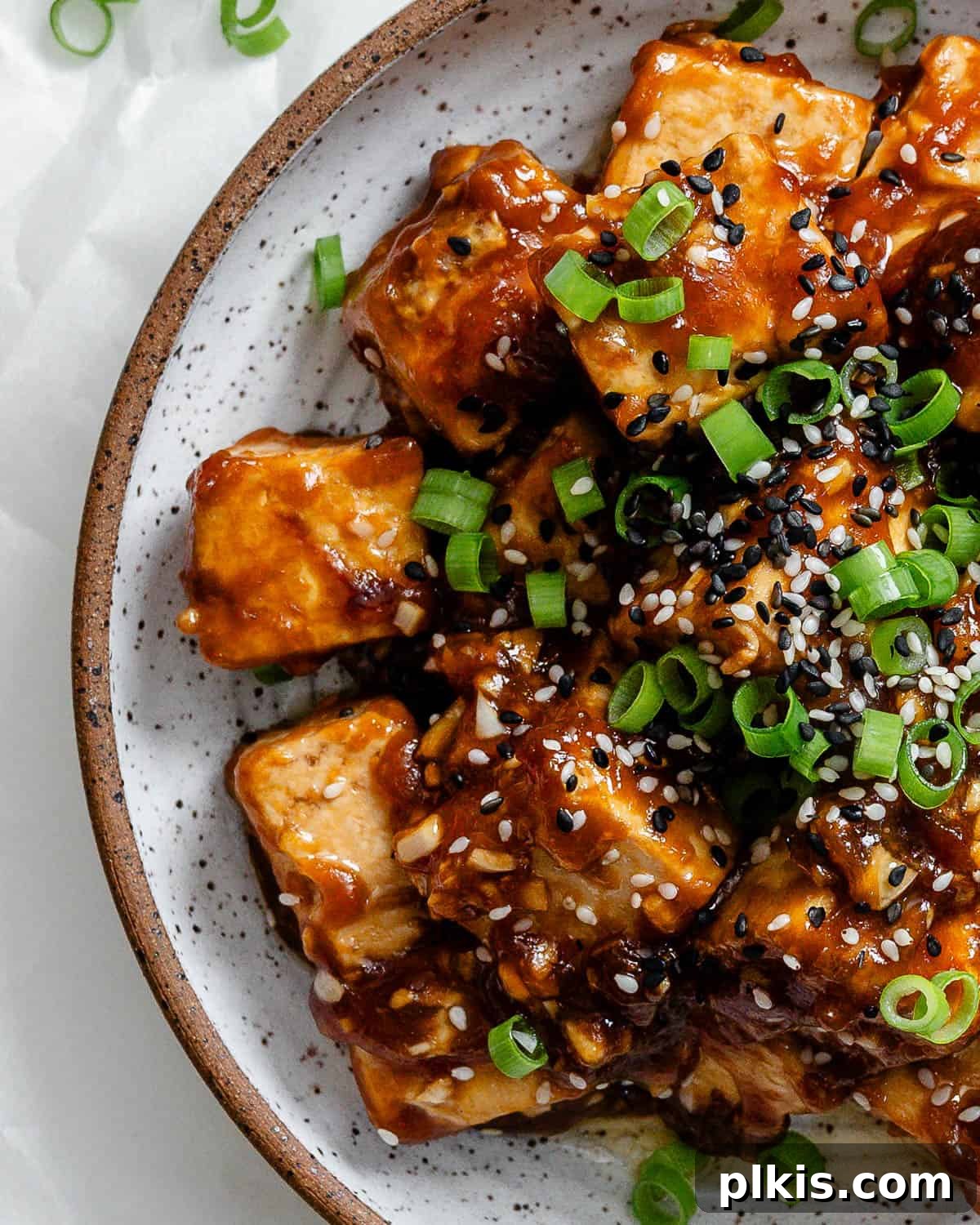 Golden Sesame Tofu 10 Completed Sticky Sesame Tofu on a plate, garnished with sesame seeds and green onions