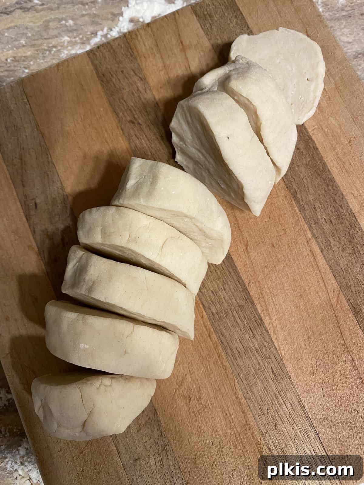 Delicate Chinese Wraps 9 A knife slicing the dough log into 8 equal portions.