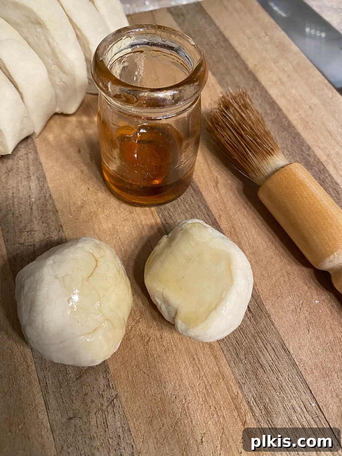 Delicate Chinese Wraps 11 A pastry brush applying sesame oil to one side of a dough circle.