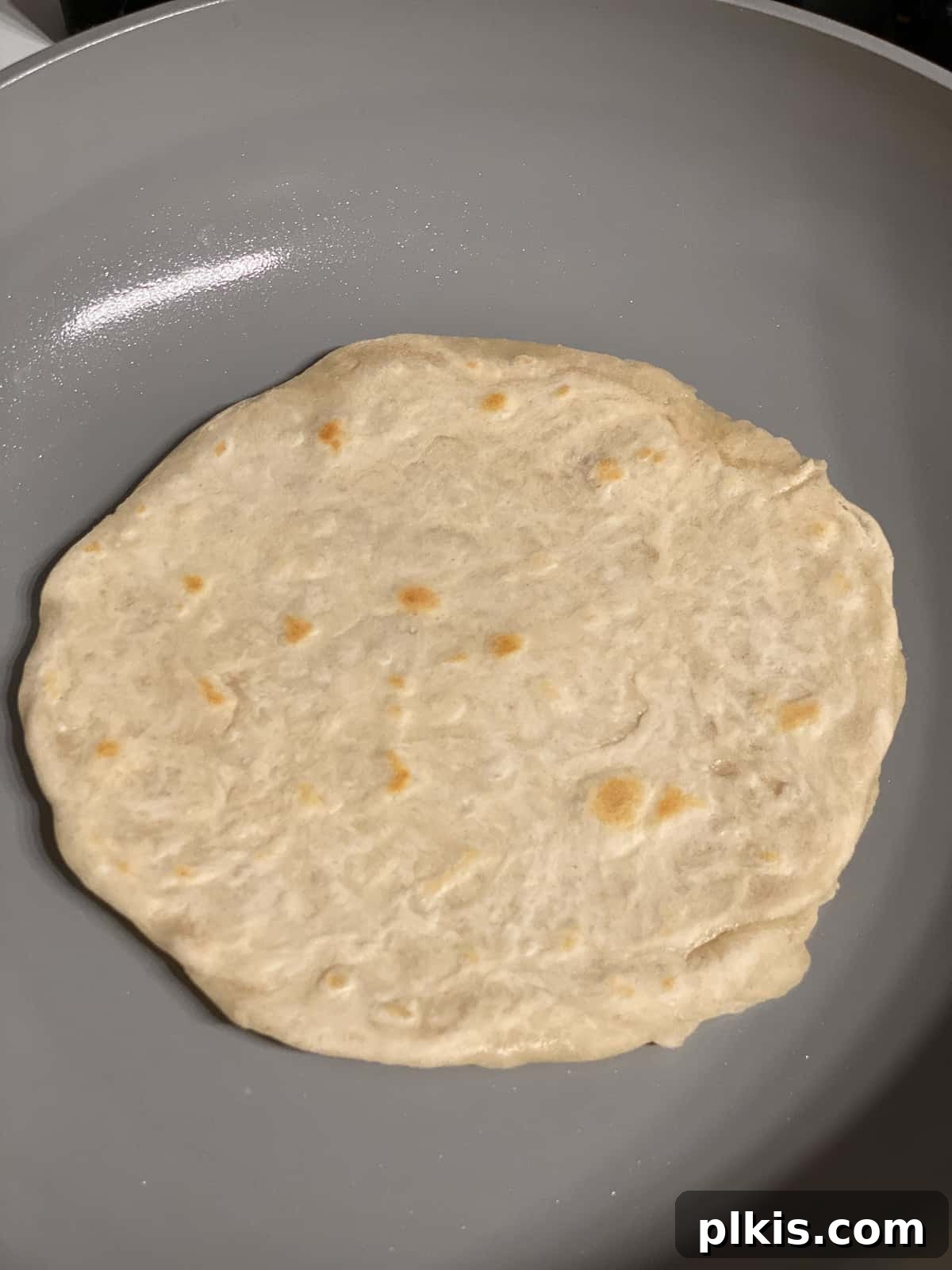 Delicate Chinese Wraps 17 A Mandarin Pancake flipped over and cooking on its second side in the skillet.
