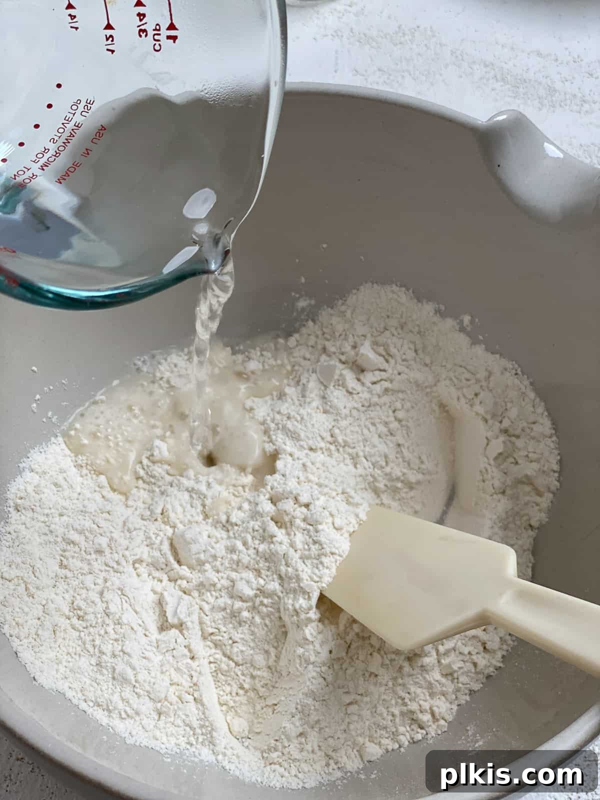 Delicate Chinese Wraps 5 Pouring boiling water into the flour mixture to begin forming the dough.