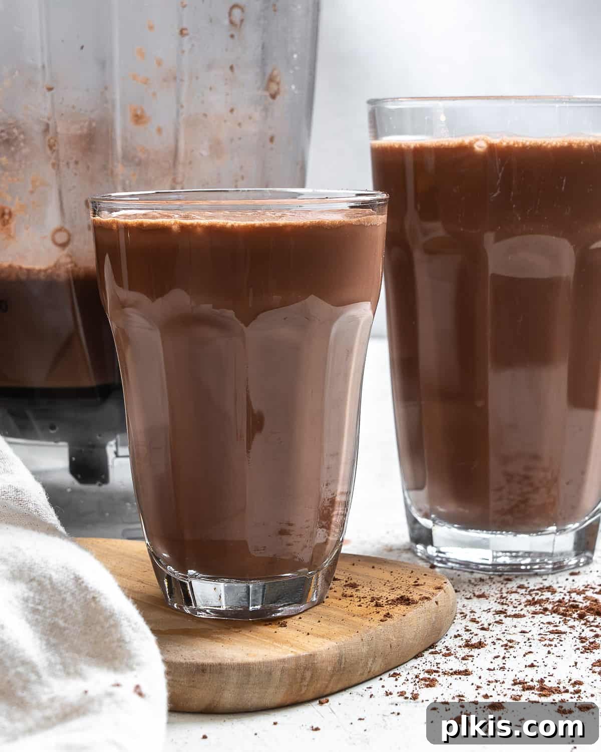 Delicious homemade Chocolate Oat Milk served in clear glasses, garnished with a sprinkle of cocoa powder.