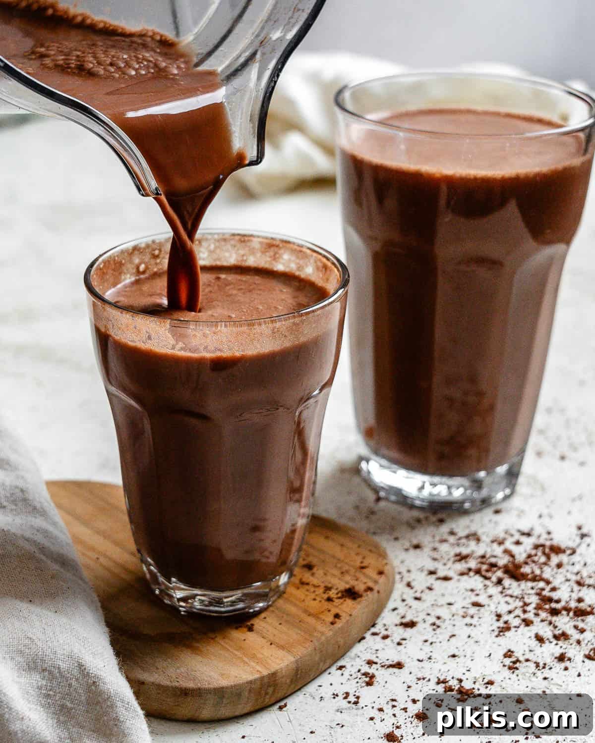 A final shot of delicious homemade Chocolate Oat Milk being poured into a glass, highlighting its smooth and inviting appearance.