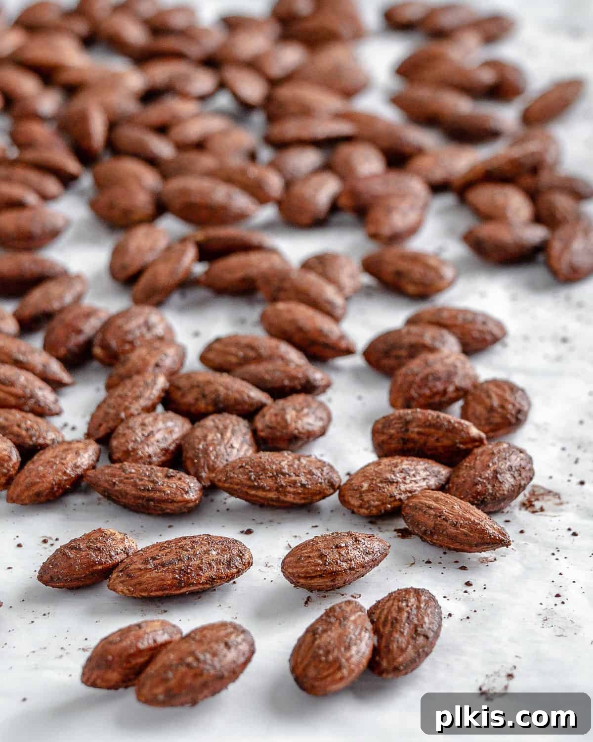 A generous serving of completed cinnamon almonds spread out against a clean white background, inviting immediate enjoyment.
