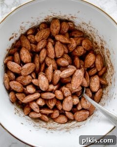 Sweet Heat Cinnamon Almonds 8 Post-mixing of spices for cinnamon almonds in a white bowl, showcasing the even coating.