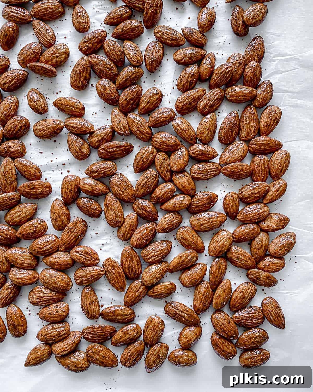 Completed cinnamon almonds perfectly roasted and arranged against a clean white surface, highlighting their inviting texture and color.