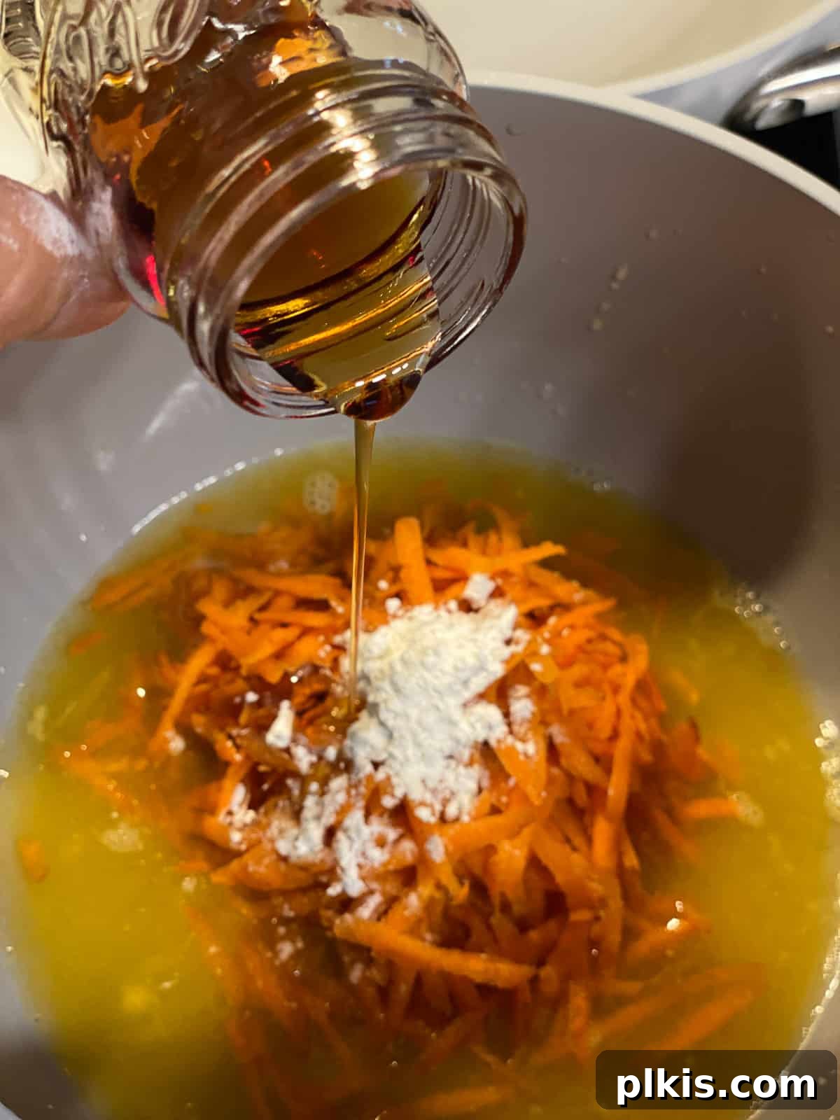 Process shot of adding a liquid ingredient, possibly orange juice or soy sauce, to the glaze mixture.