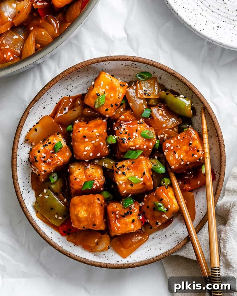 Golden Sweet and Sour Tofu 2 A vibrant dish of homemade Sweet and Sour Tofu, garnished with green onions and sesame seeds, ready to be served.