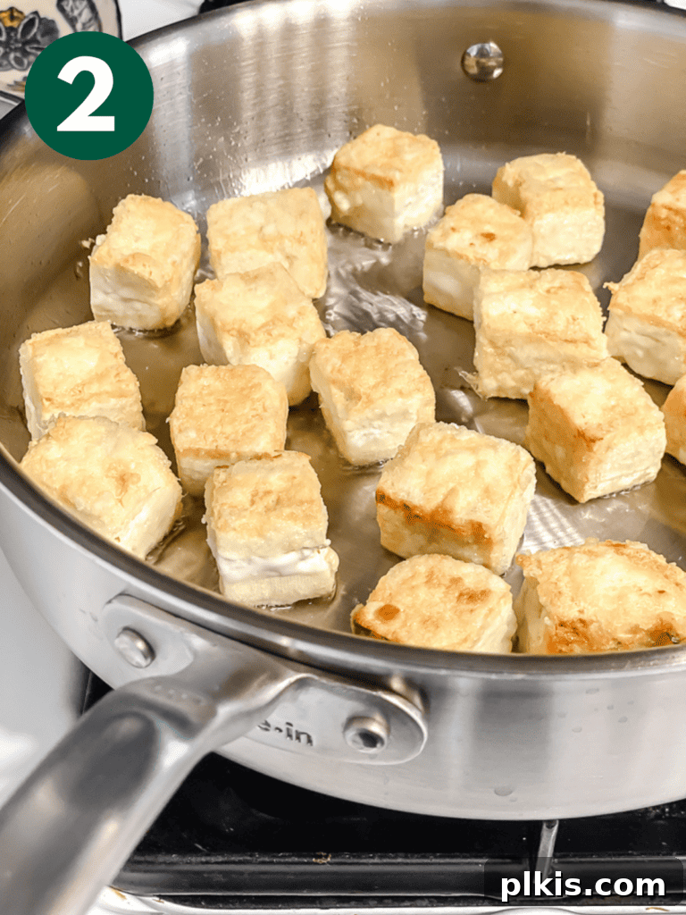 Golden Sweet and Sour Tofu 5 Process shot of crispy tofu cooking in a hot skillet, showcasing the golden-brown crust.
