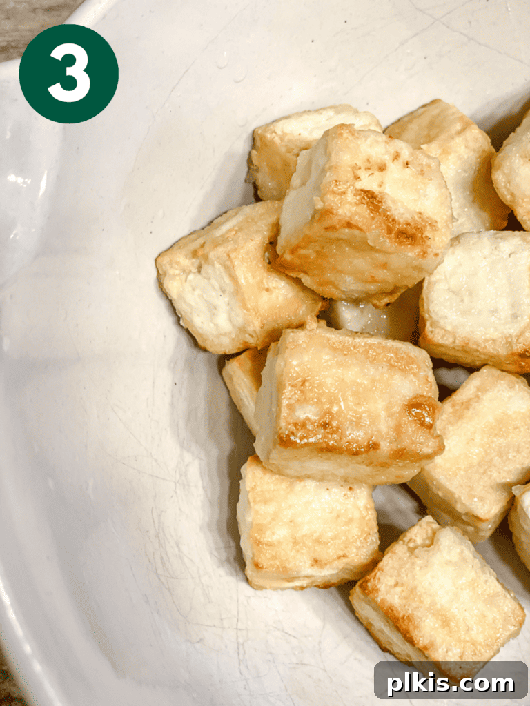 Golden Sweet and Sour Tofu 6 Process shot showing the perfectly cooked, golden and crispy tofu cubes transferred to a separate bowl.