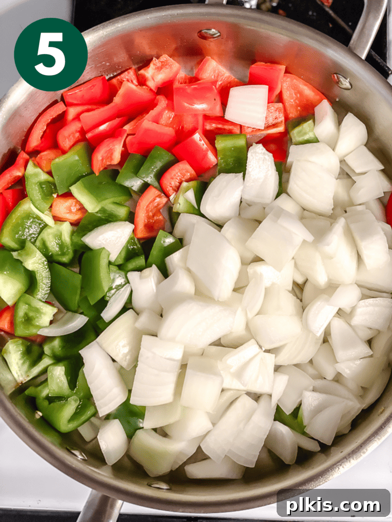 Golden Sweet and Sour Tofu 8 Process shot showing chopped bell peppers and onions added to the pan for sautéing.