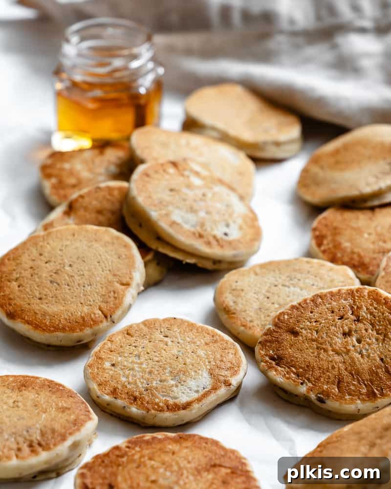 several completed Easy Vegan Pancakes [Regular or Mini] on a white surface 