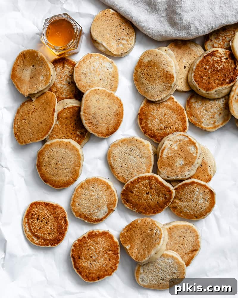 several completed Easy Vegan Pancakes [Regular or Mini] on a white surface