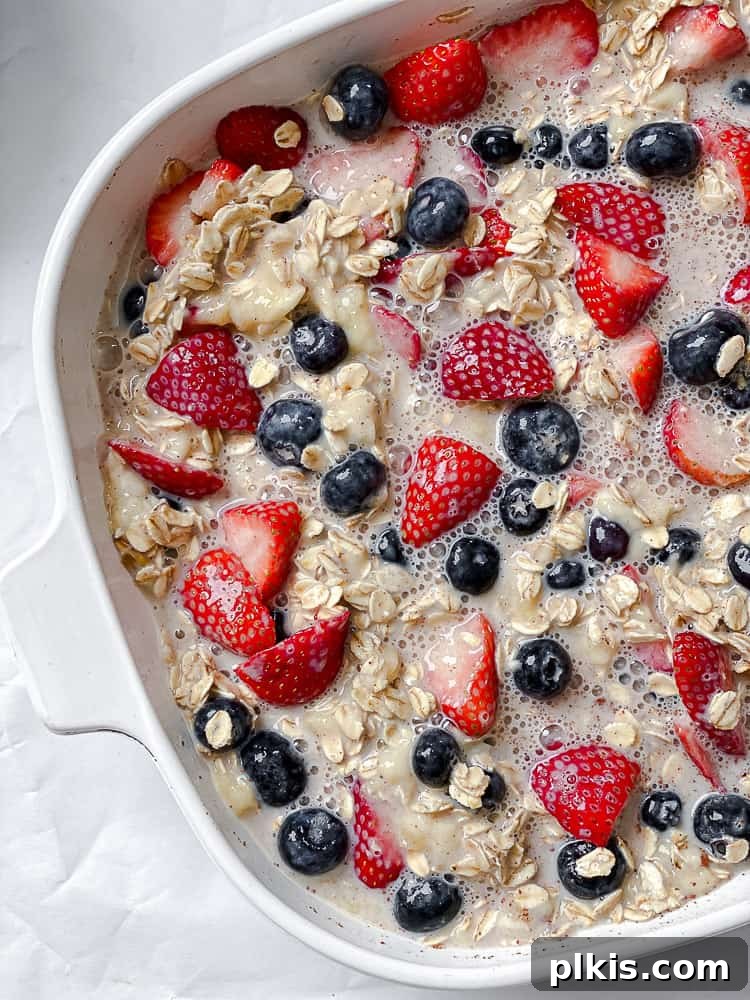 Vegan Berry Baked Oatmeal 6 Process shot showing unbaked oatmeal with berries in a baking dish, ready for the oven.