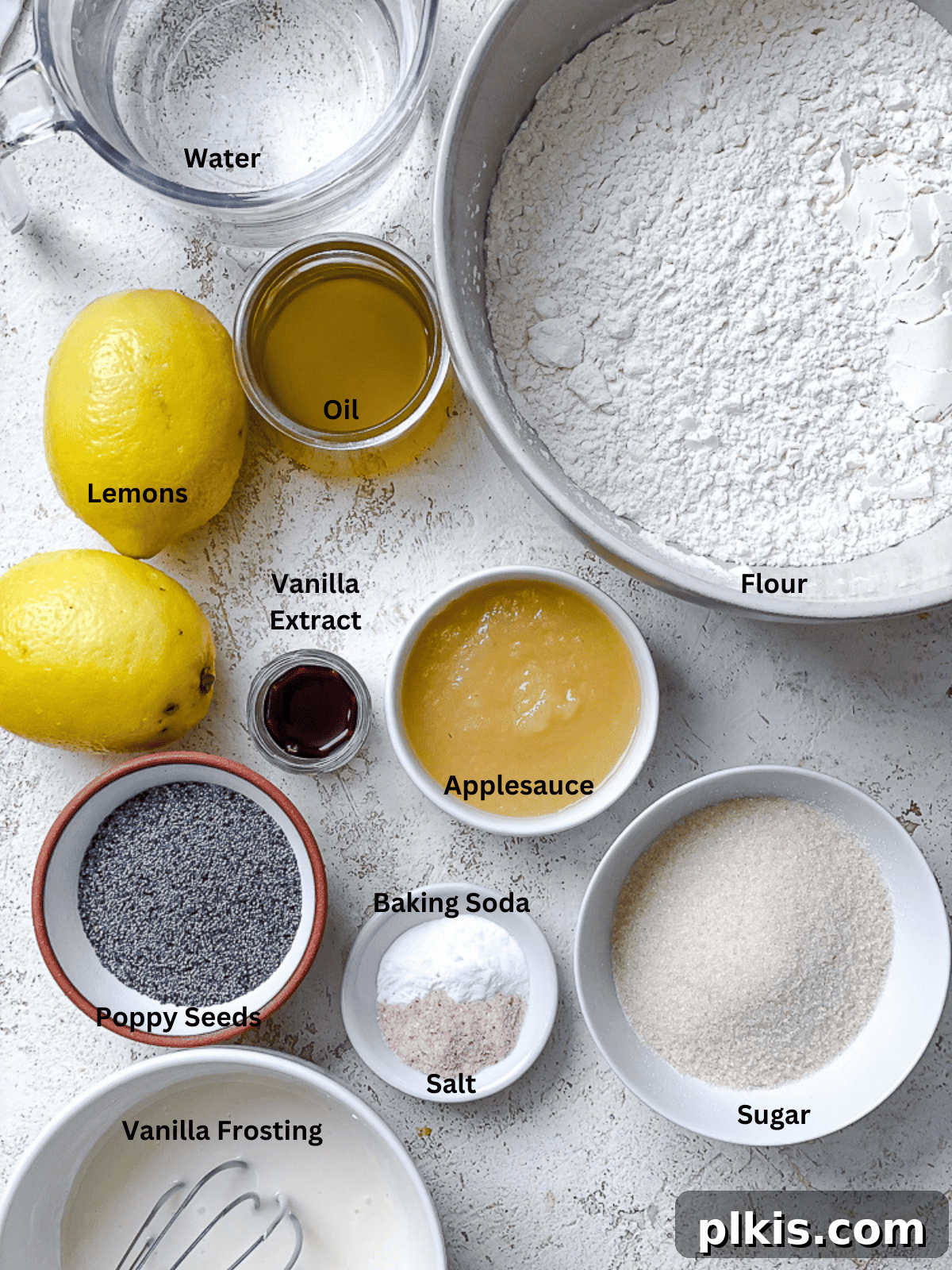Zesty Lemon Poppy Seed Cake 3 A collection of ingredients for lemon poppy seed cake, neatly arranged with labels.