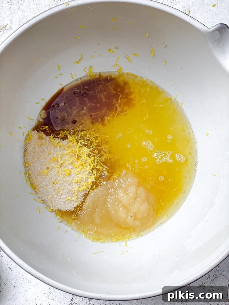 Zesty Lemon Poppy Seed Cake 4 Process shot showing wet ingredients being mixed in a large bowl.