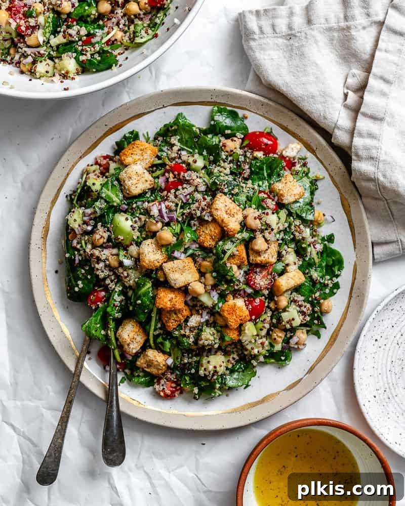 Power-Packed Kale Quinoa Salad 2 A visually appealing Kale Quinoa Salad, beautifully plated on a pristine white surface, highlighting its fresh ingredients and vibrant colors.