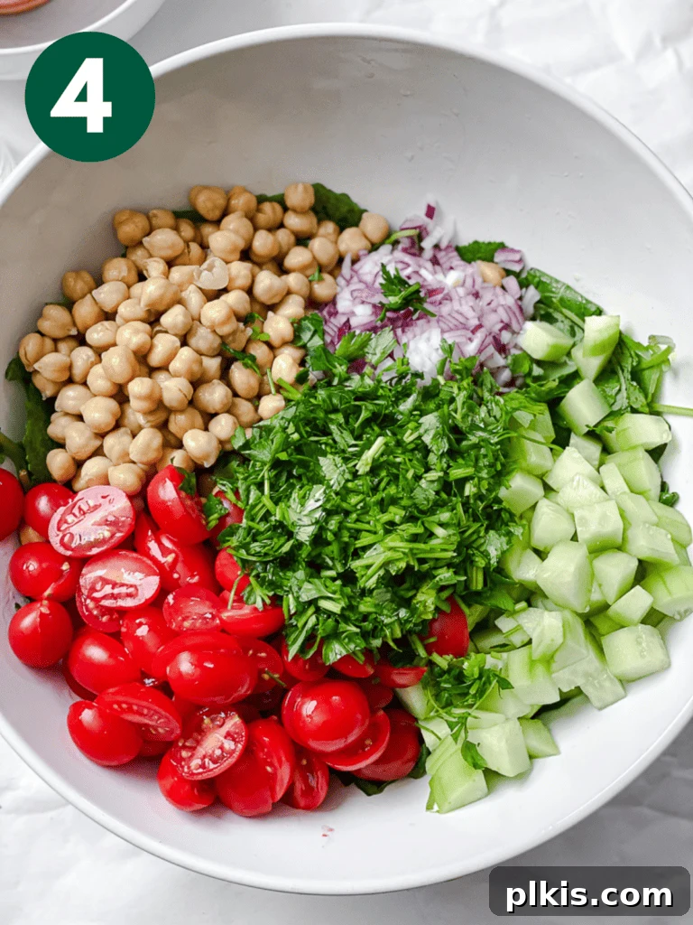 Power-Packed Kale Quinoa Salad 7 A process shot showing a colorful medley of fresh ingredients already combined in a large salad bowl, creating a vibrant base.