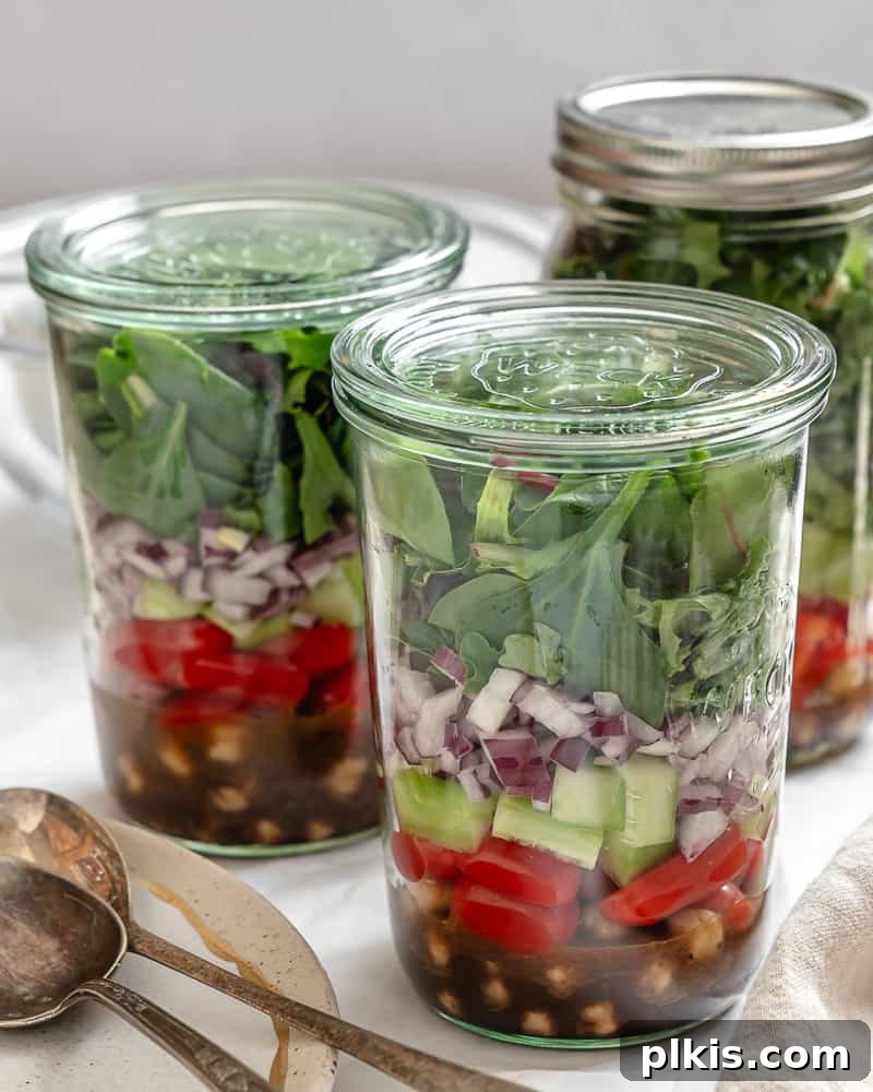 Jarred Quinoa Chickpea Power Salad 2 Vibrant Quinoa Chickpea Salad perfectly layered in a mason jar, ready for meal prep, set against a clean white background.
