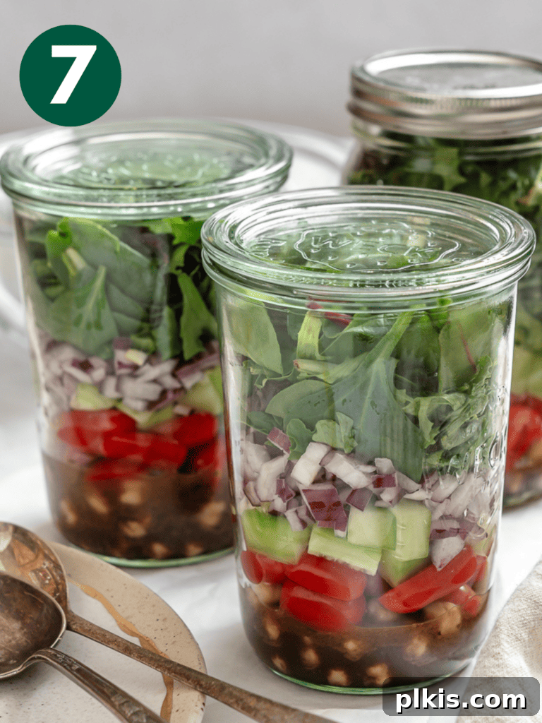 Jarred Quinoa Chickpea Power Salad 10 A perfectly layered Quinoa Chickpea Salad in a mason jar, ready to eat or store, against a white background.