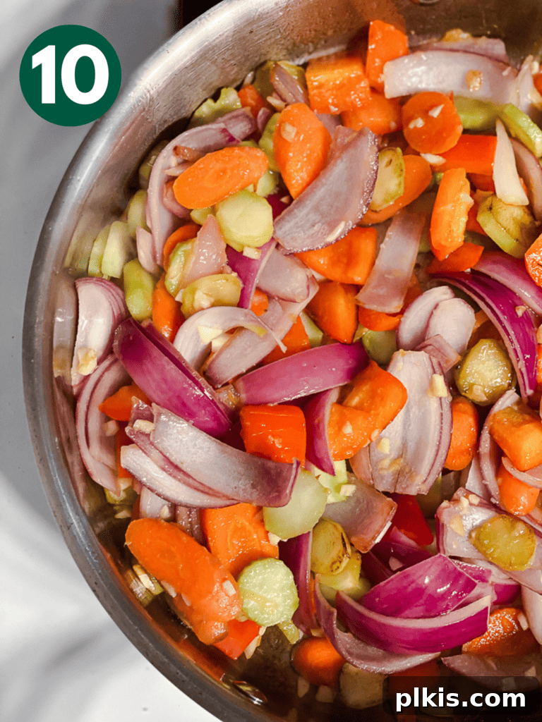 Process shot showing the vegetables continuing to cook and soften in the pan.