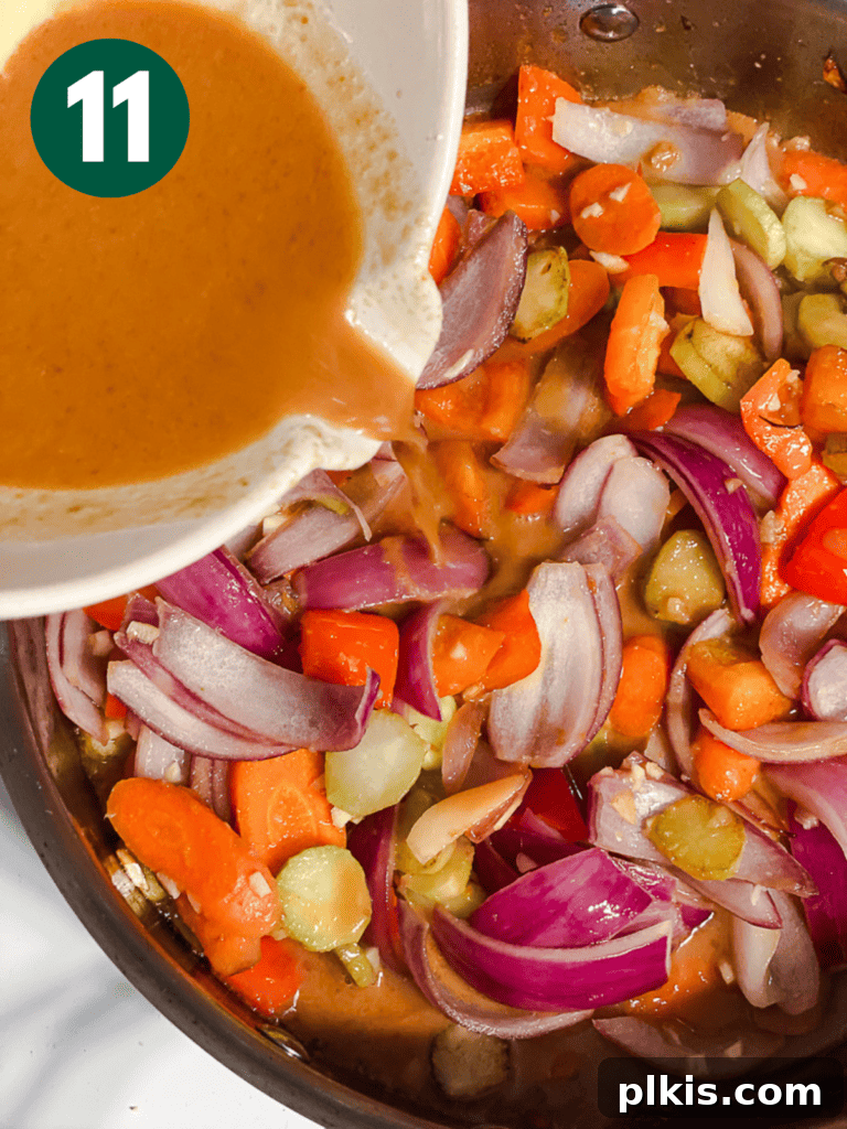 Process shot of pouring the cornstarch-based stir-fry sauce into the pan with vegetables.