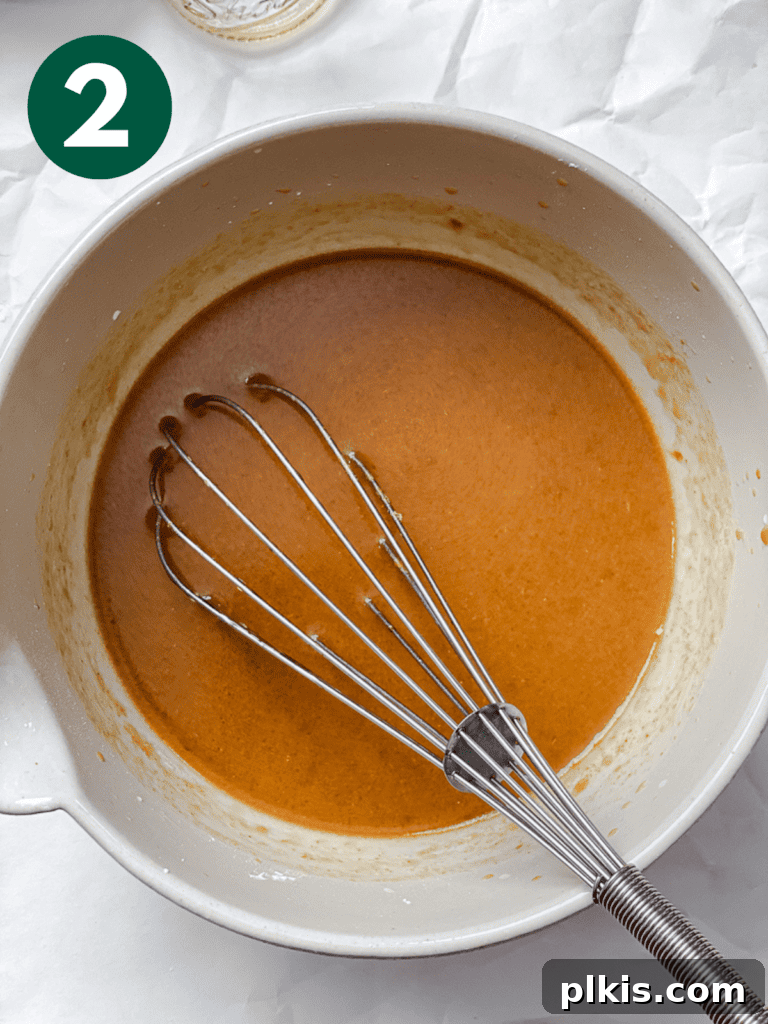 Process shot of combining all sauce ingredients in a bowl with a whisk.