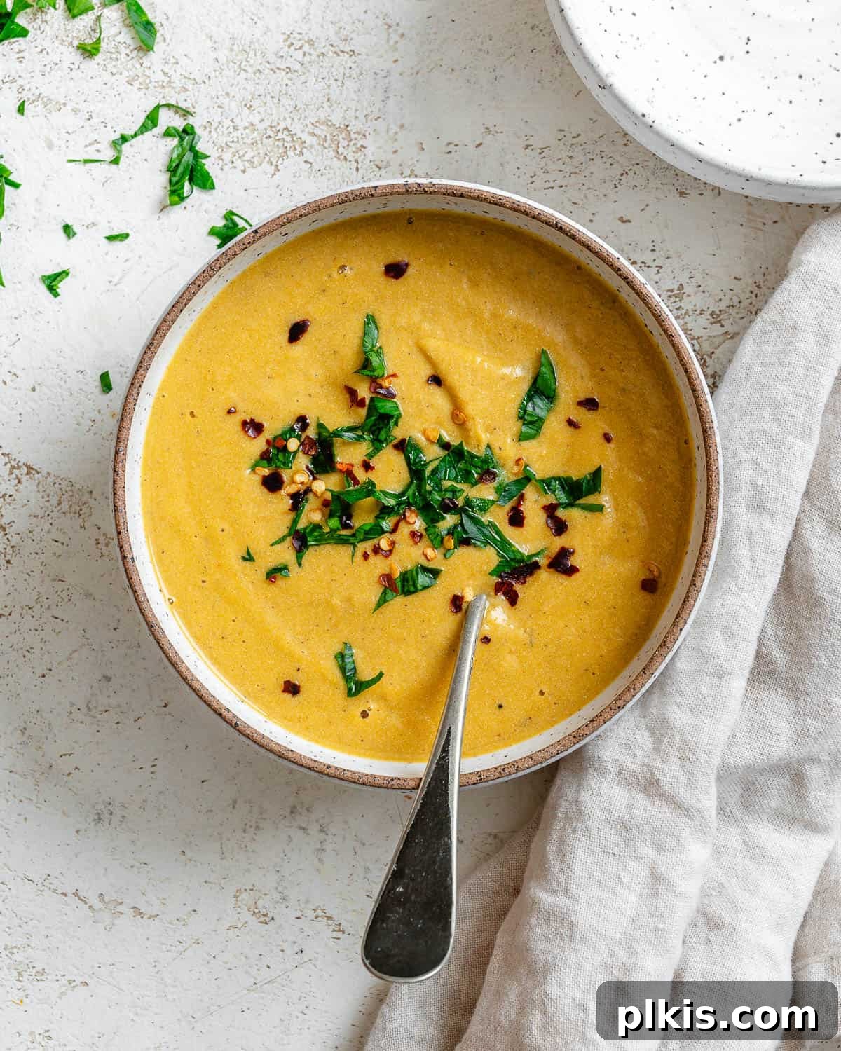 Cozy Slow Cooker Spiced Pumpkin Bisque 2 completed Slow Cooker Pumpkin Soup on a white surface