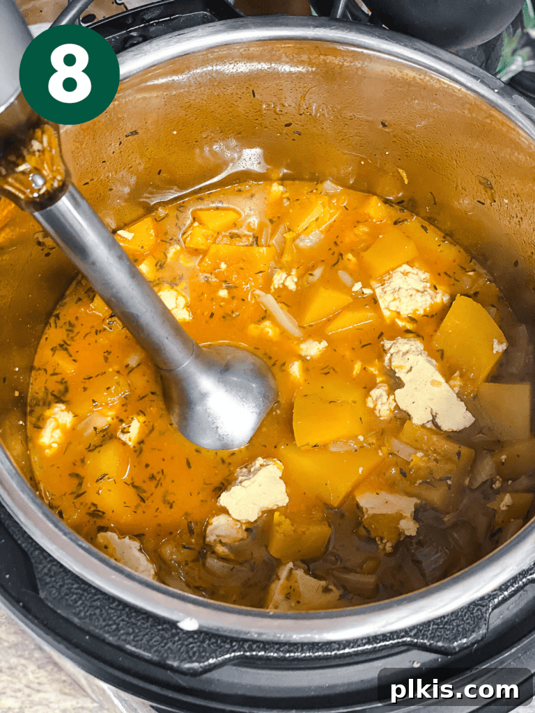 Cozy Slow Cooker Spiced Pumpkin Bisque 11 process shot showing immersion blender being used in pot