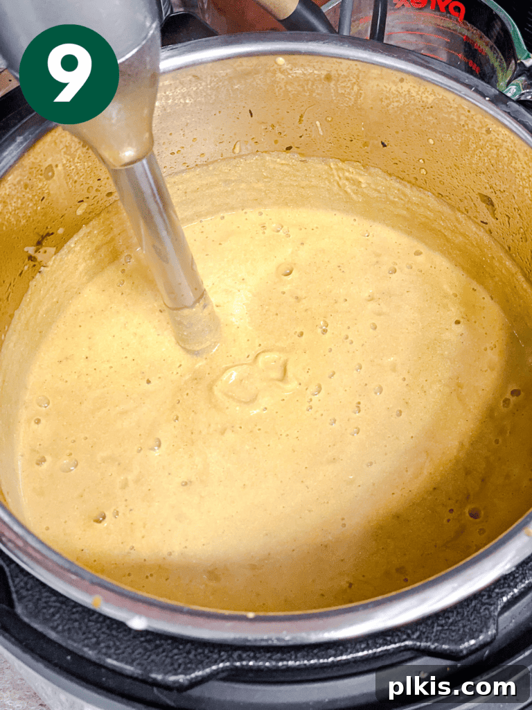 Cozy Slow Cooker Spiced Pumpkin Bisque 12 process shot showing immersion blender being used in pot