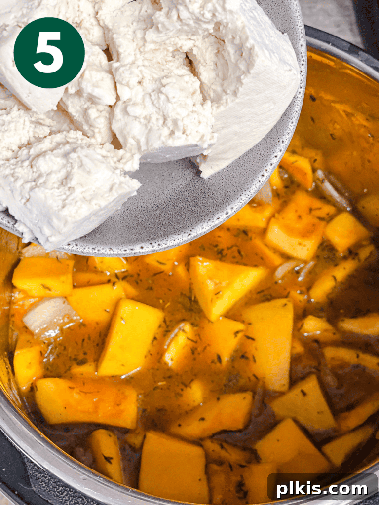 Cozy Slow Cooker Spiced Pumpkin Bisque 8 process shot showing adding tofu to pot