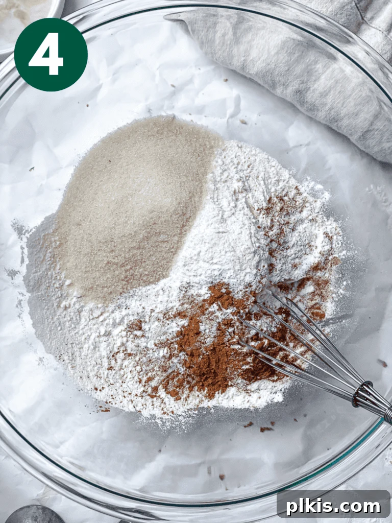 A process shot showing dry ingredients (flour, sugar, spices, leavening agents) being mixed in a large bowl before adding liquids.