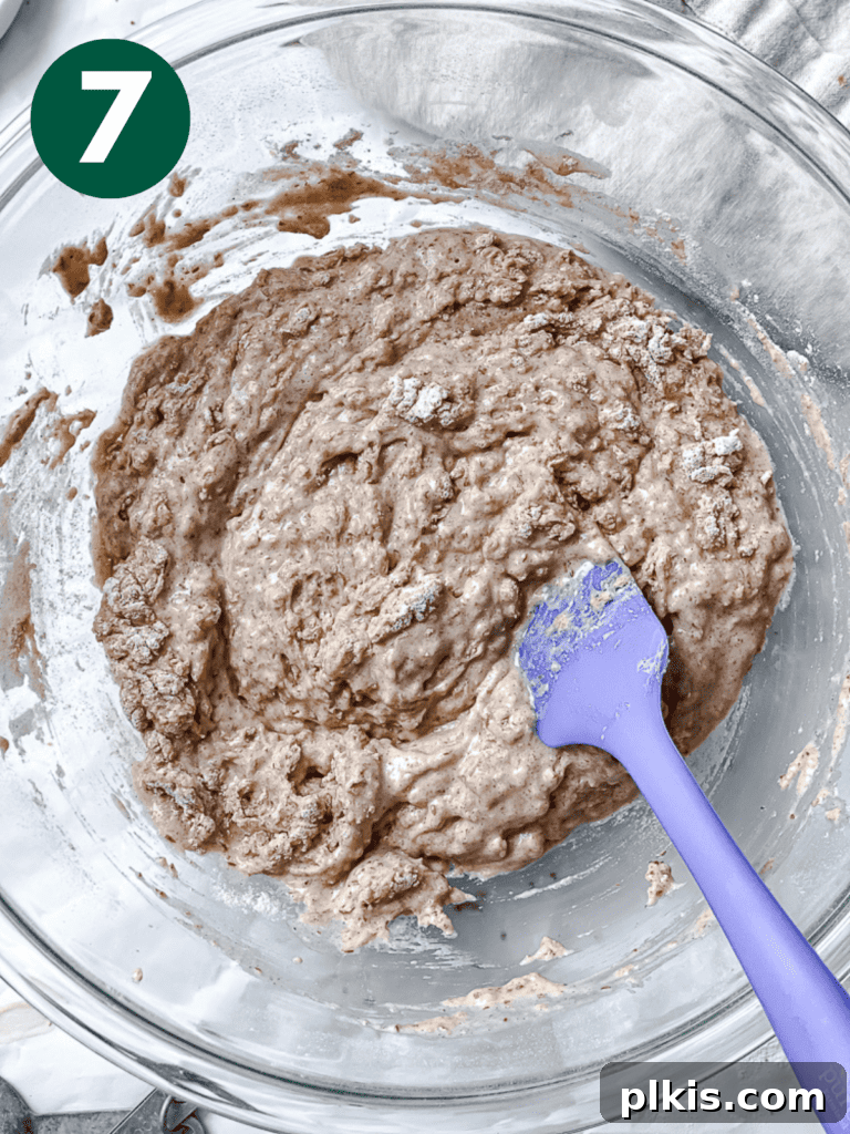 A process shot showing the batter being gently mixed after the wet ingredients have been added to the dry.
