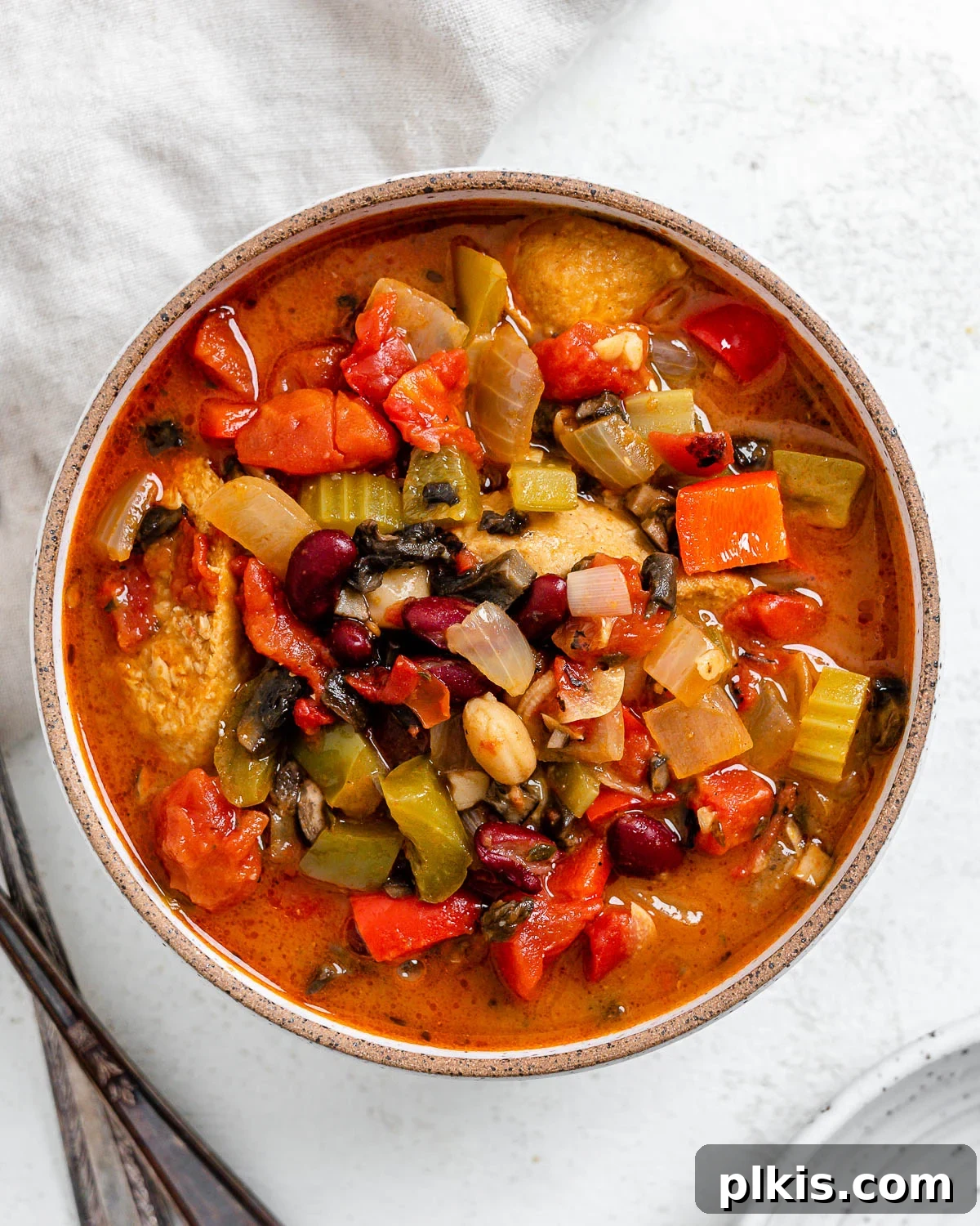 Hearty Plant-Based Gumbo 2 completed vegan gumbo in a white bowl alongside utensils, steam rising