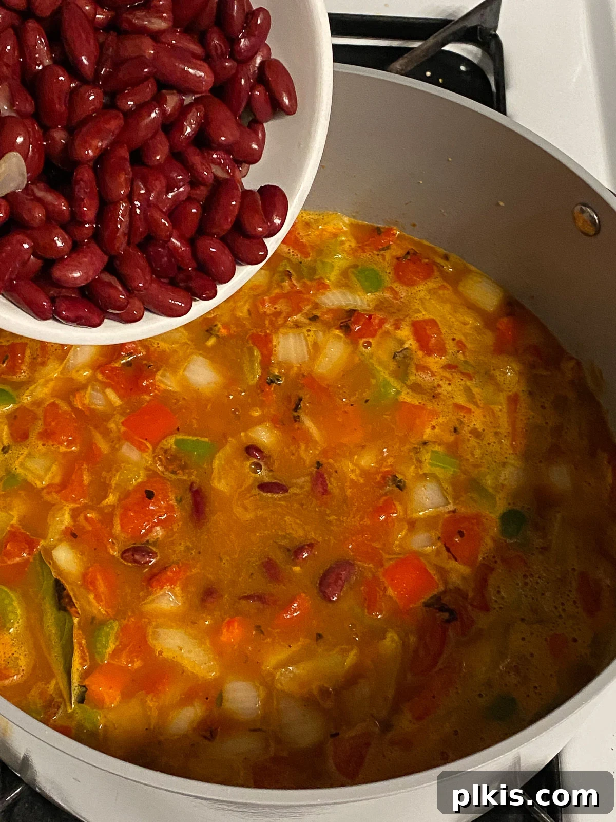 Hearty Plant-Based Gumbo 12 process shot of kidney beans being added to the gumbo in the pot