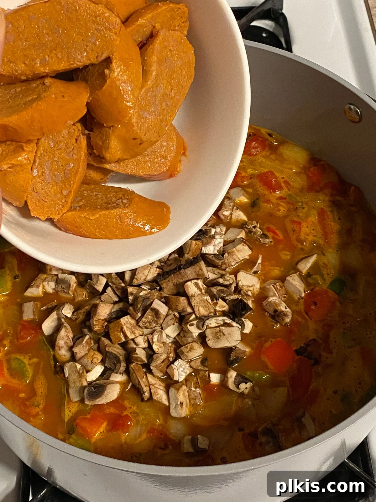 Hearty Plant-Based Gumbo 15 process shot of vegan sausage slices being added to the gumbo