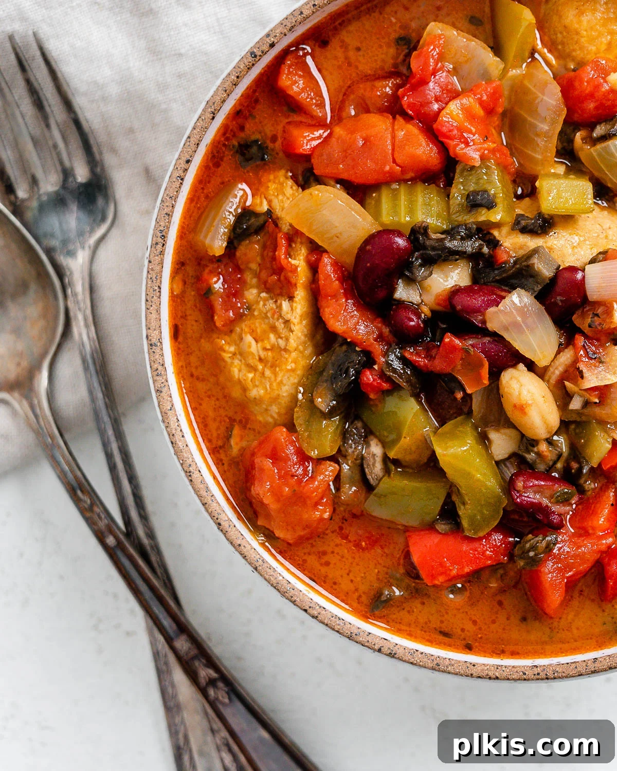 Hearty Plant-Based Gumbo 17 completed vegan gumbo in a white bowl alongside utensils, ready to be enjoyed