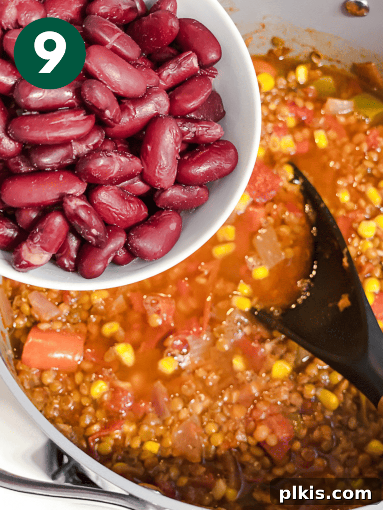 Hearty Lentil and Bean Chili 12 Canned kidney beans being added to the simmering chili, enriching the texture and protein content.