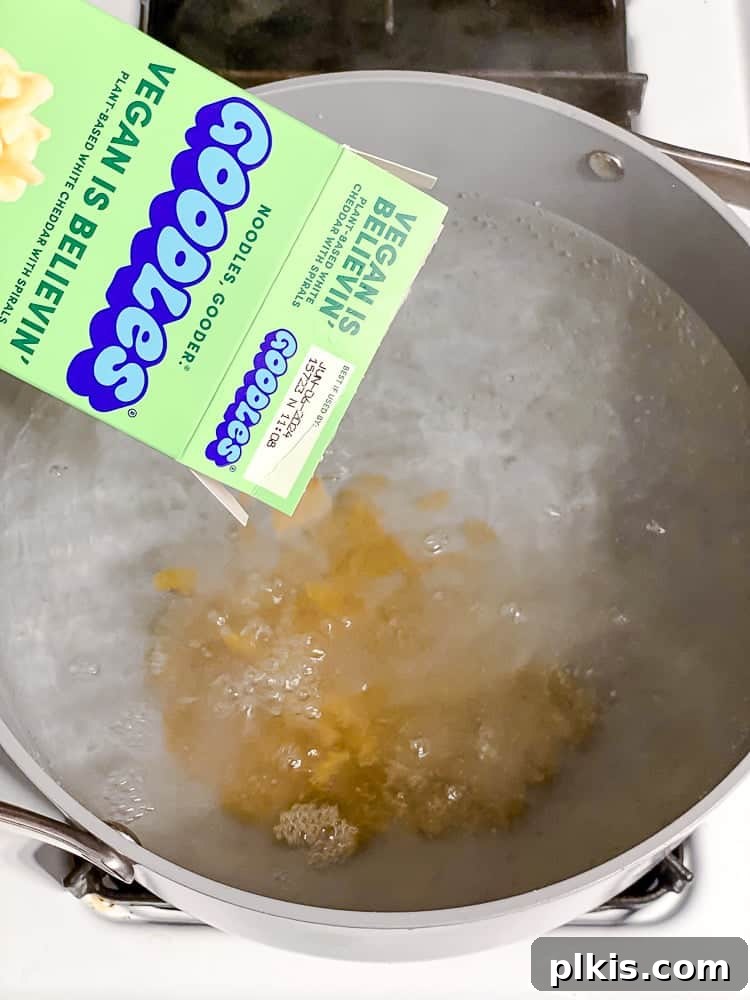 Elevate Your Boxed Mac and Cheese 5 process shot of adding pasta to pot