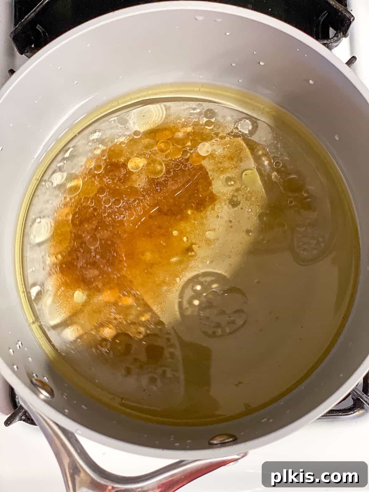 Vegan Churro Bliss 6 Wet ingredients – oil, brown sugar, and water – simmering in a saucepan on the stove, ready for churro dough preparation.