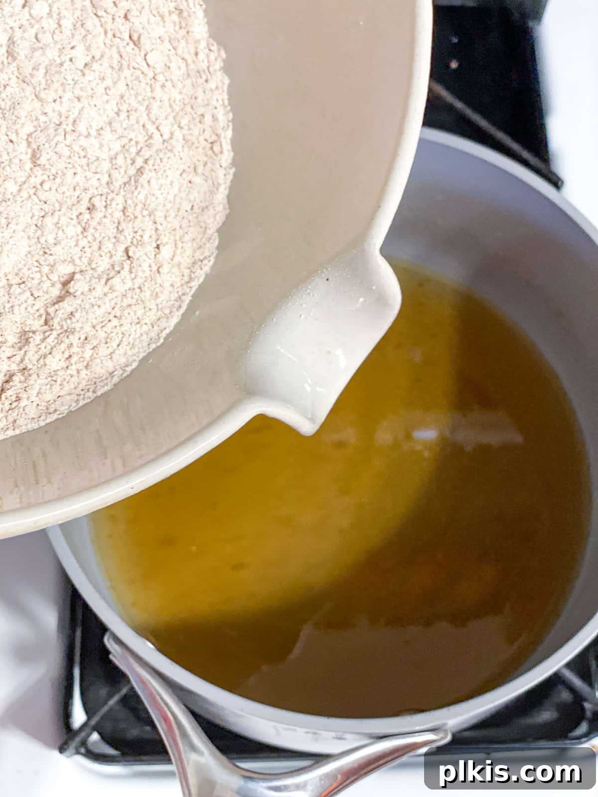 Vegan Churro Bliss 7 Dry ingredients being poured into the saucepan with wet ingredients for vegan churro dough, ready for mixing.