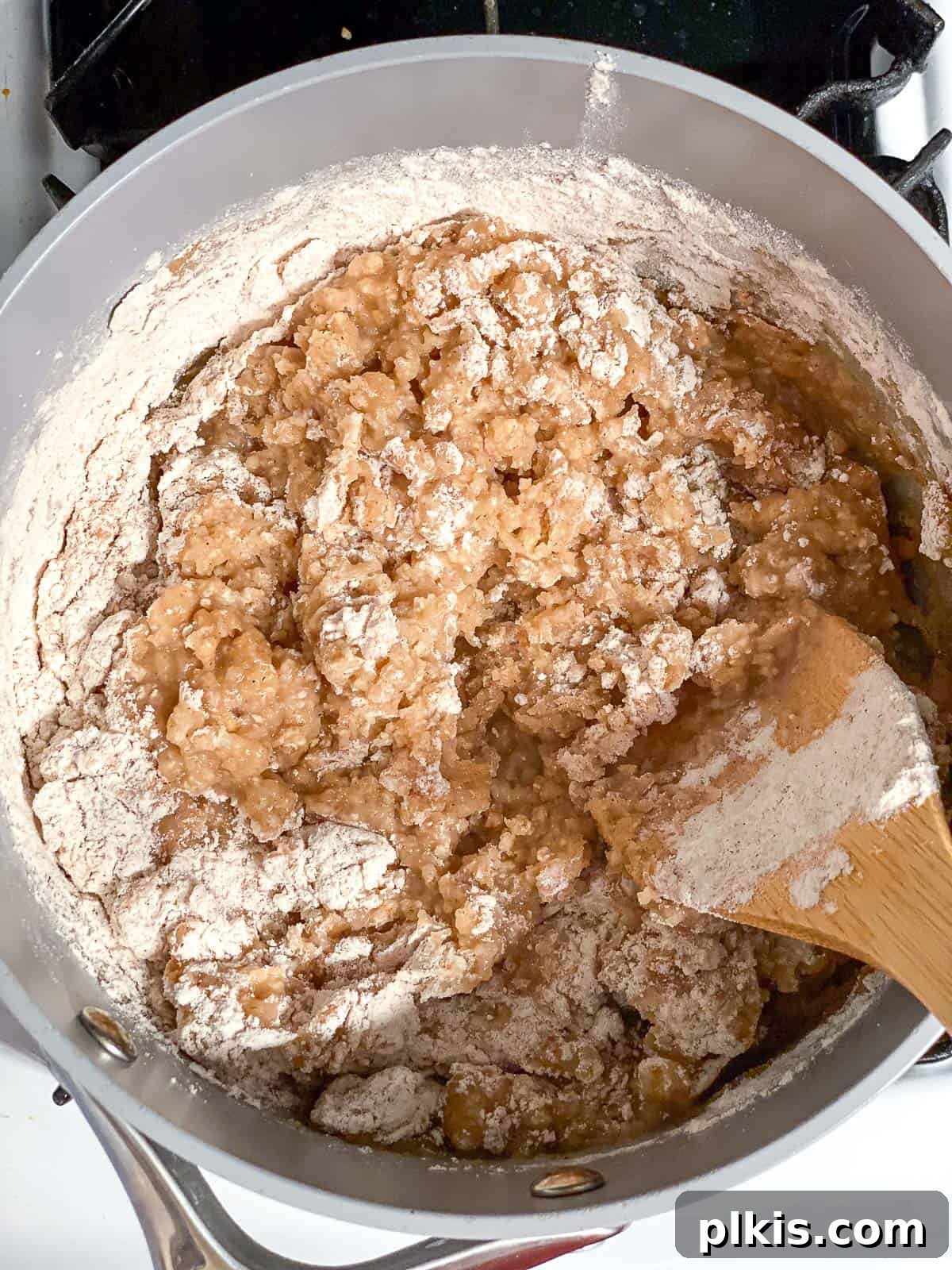 Vegan Churro Bliss 8 Stirring vegan churro dough in a saucepan with a wooden spoon, forming a cohesive ball.