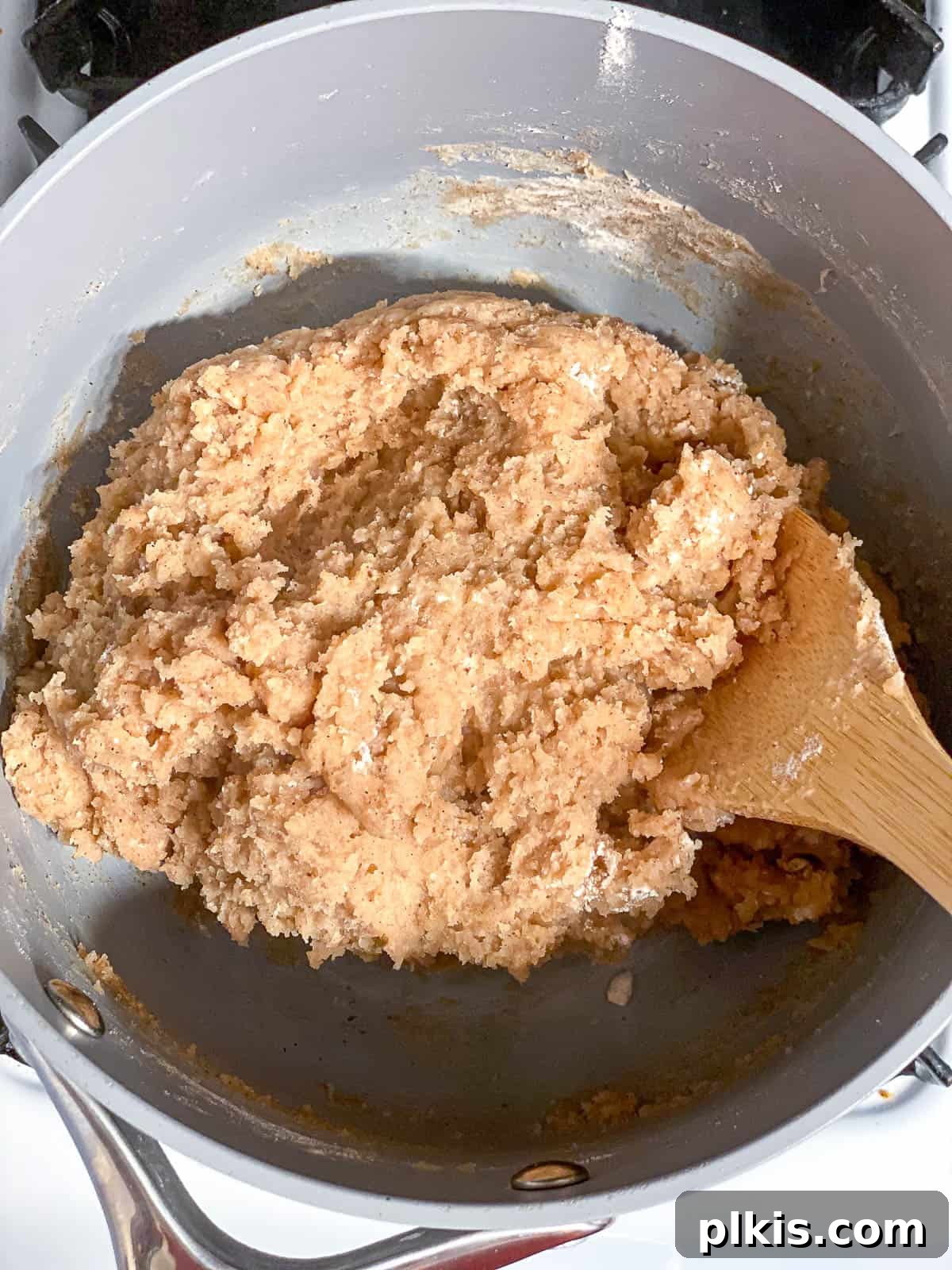 Vegan Churro Bliss 9 The fully formed vegan churro dough ball, stirred in a saucepan with a wooden spoon, cooling.