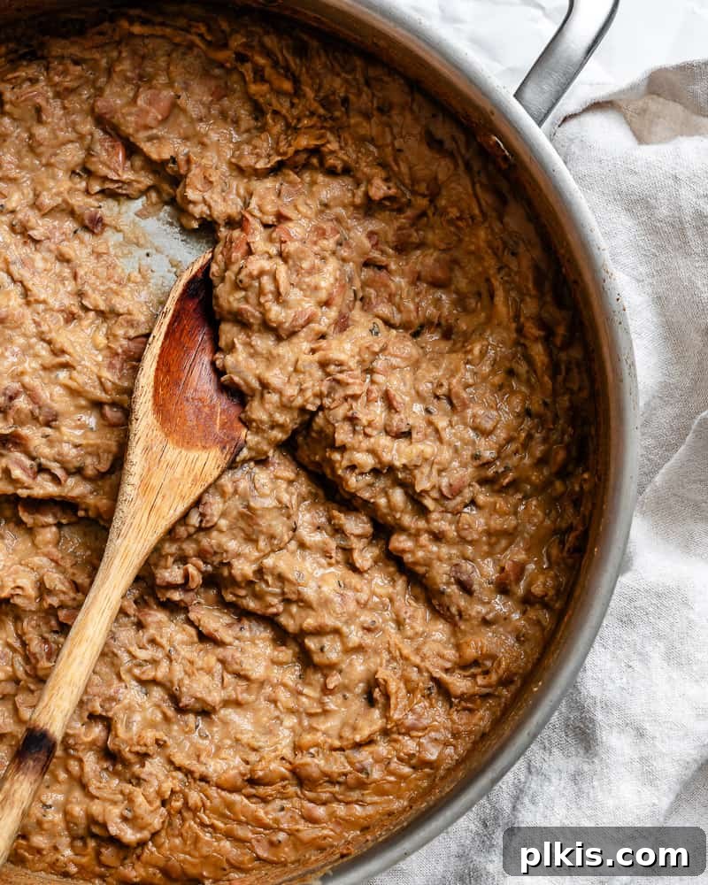 Creamy Plant-Powered Refried Beans 2 A pot filled with creamy, rich, and flavorful vegan refried beans, ready to be served