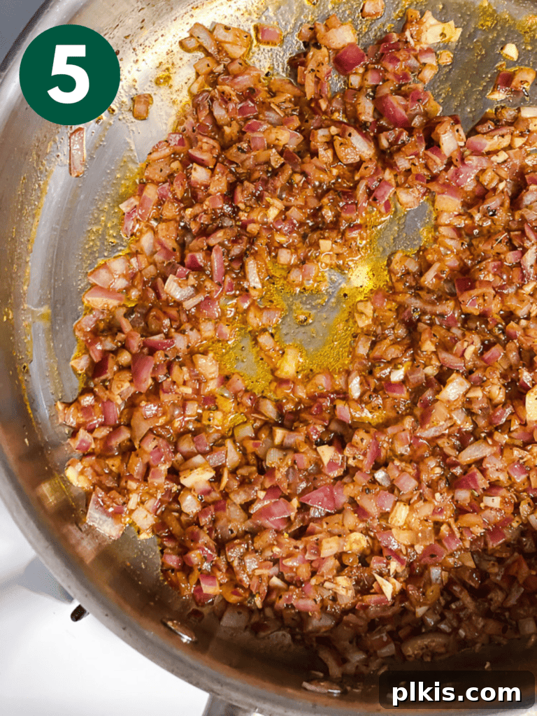 Creamy Plant-Powered Refried Beans 8 Process shot of pinto beans, spices, and aromatics cooking together in a pot