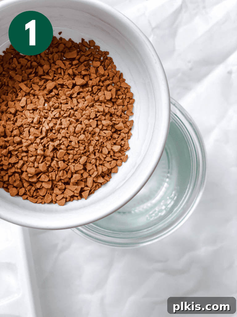 Coffee Kick Smoothie 4 A close-up shot of instant coffee granules being added to a cup of cold water, beginning the preparation process for the coffee smoothie.