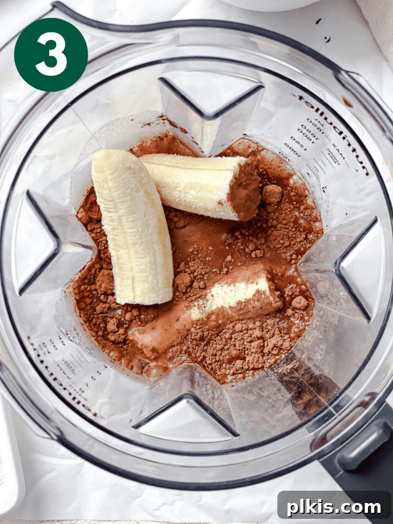 Coffee Kick Smoothie 6 All the core ingredients for the coffee smoothie, including coffee, plant milk, oats, bananas, cocoa, and sweetener, ready in a blender before blending.
