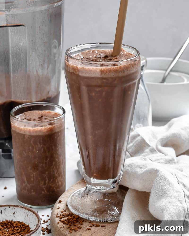 Coffee Kick Smoothie 8 Two aesthetically arranged glasses of finished coffee smoothie, garnished with a sprinkle of coffee, inviting to be enjoyed.