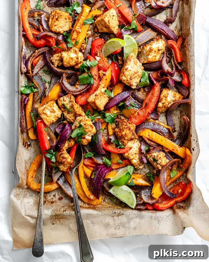 Zesty Tofu Fajita Feast 6 A close-up shot of roasted taco-seasoned tofu chunks, onion, and bell peppers fresh out of the oven, arranged artfully on a parchment-lined sheet pan.