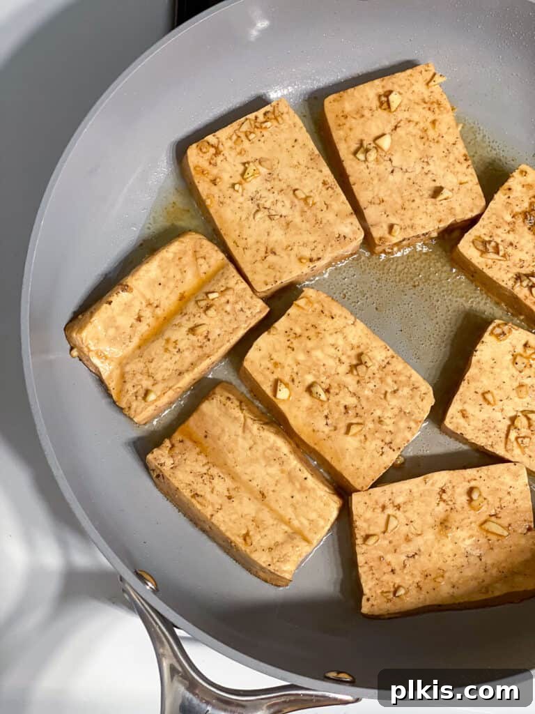 Effortless Tofu Adobo 11 Process shot showing tofu browning on a skillet.